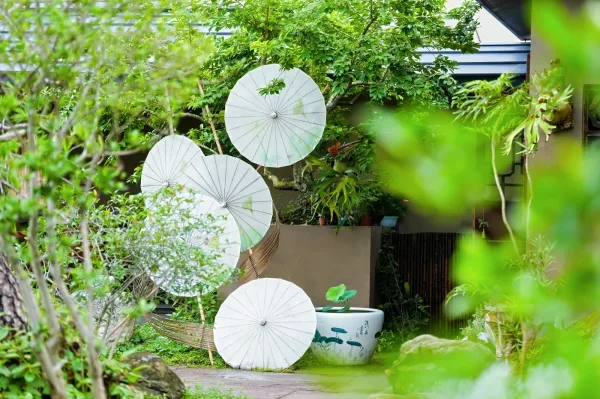 庭院墙面悬挂着一组白色油纸伞装饰